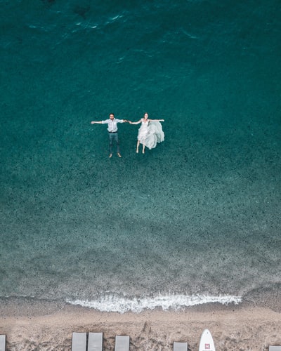 男人和女人漂浮在蓝色的海滩
